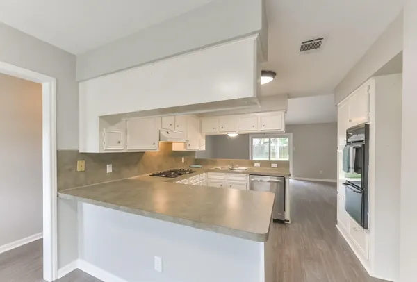 a view of a kitchen with kitchen island a counter top space a sink stainless steel appliances and cabinets