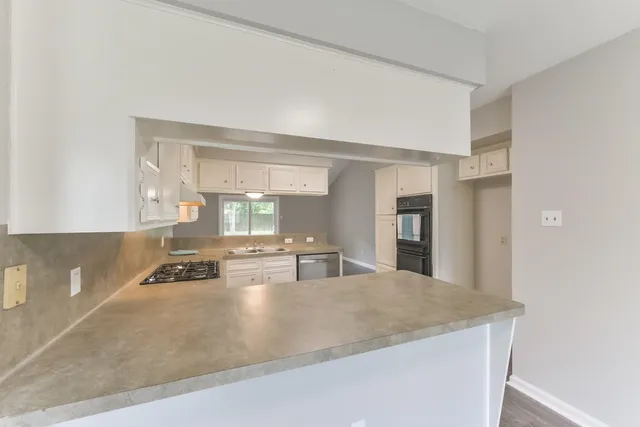 a kitchen with kitchen island a sink a stove and a refrigerator