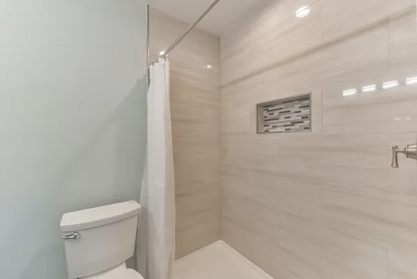 a bathroom with a toilet and a shower