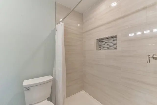 a bathroom with a toilet and a shower