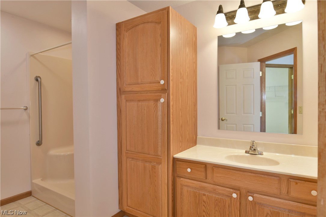 2033 East River Road, Unit 11 Newton Falls, OH 44444 - Photo 24 of 35 Bathroom featuring large vanity, a shower, mirror, and light tile flooring