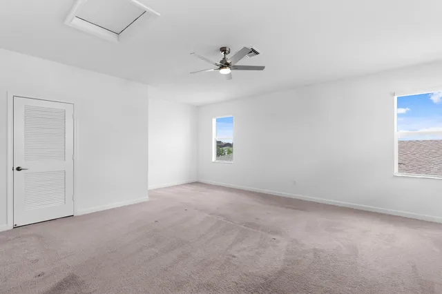 an empty room with a window and ceiling fan