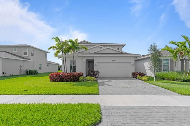 a front view of a house with a yard and garage