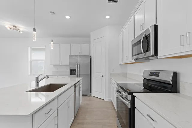 a kitchen with stainless steel appliances granite countertop a sink stove and refrigerator