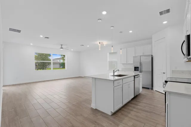 a kitchen with stainless steel appliances granite countertop a stove a sink and a refrigerator