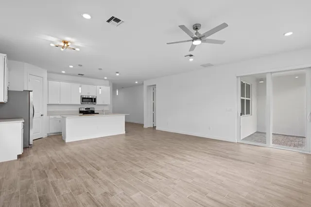 a view of kitchen with stainless steel appliances refrigerator stove microwave and cabinets