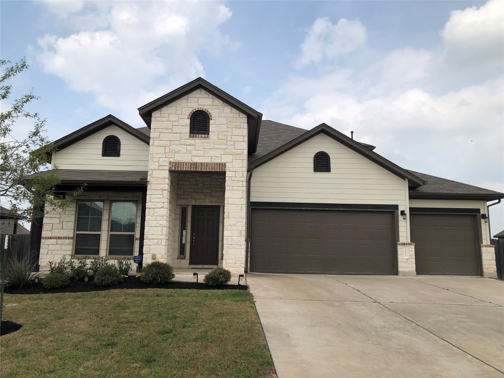 a front view of a house with a yard and garage