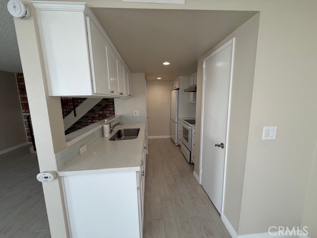 2070 Avenida Placida, Unit 3 Simi Valley, CA 93063 - Photo 6 of 25 a kitchen with a refrigerator a sink and a stove top oven