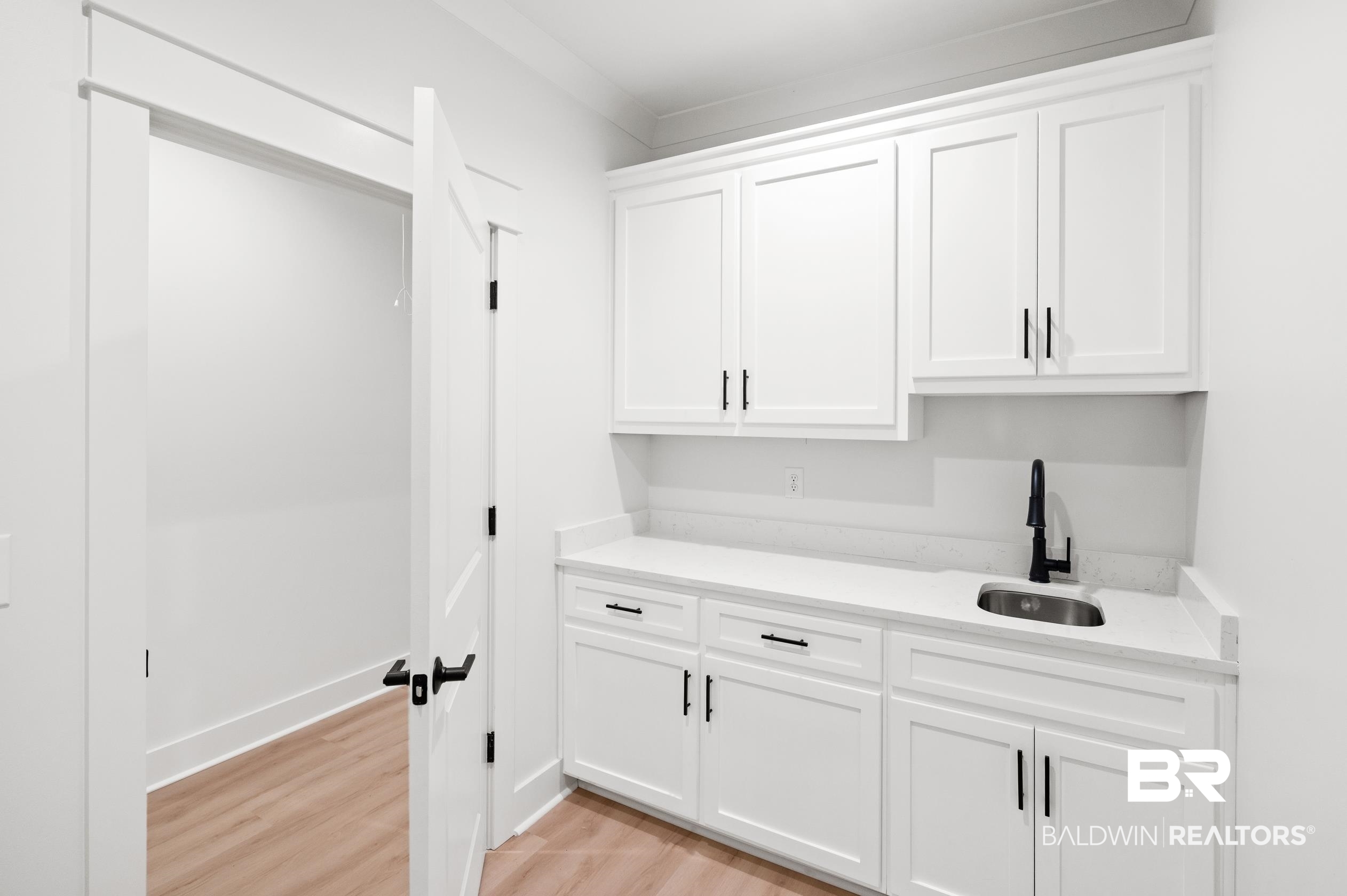 28889 Canal Road Orange Beach, AL 36561 - Photo 18 of 55 Interior space featuring sink, white cabinets, and light wood-type flooring
