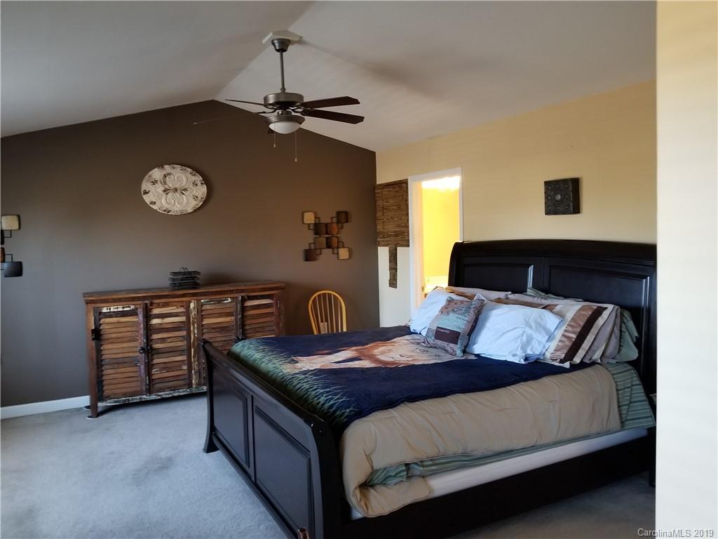 5655 Stafford Road Charlotte, NC 28215 - Photo 7 of 13 a bedroom with a bed and a chandelier