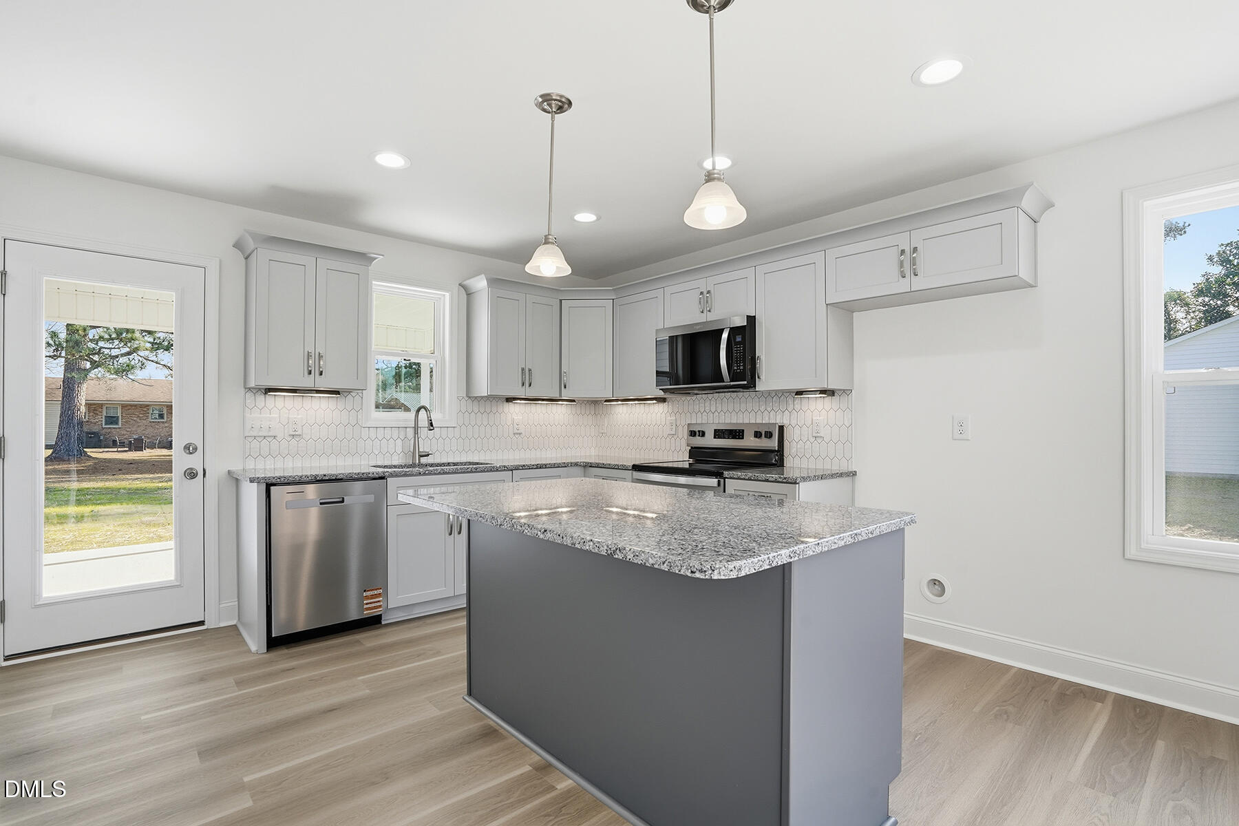 218 Rae Street Warsaw, NC 28398 - Photo 10 of 31 a kitchen with stainless steel appliances granite countertop a sink a stove a refrigerator cabinets and a wooden floor