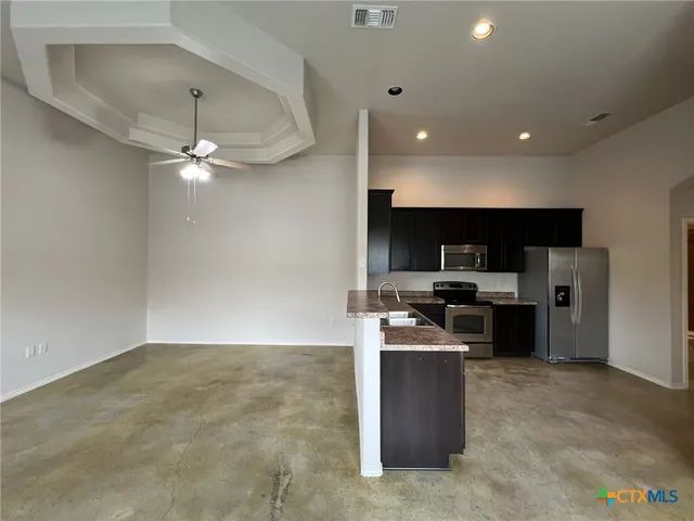 a kitchen with kitchen island stainless steel appliances a counter top space cabinets and stove top oven