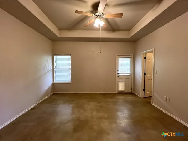 en empty room with windows and fan