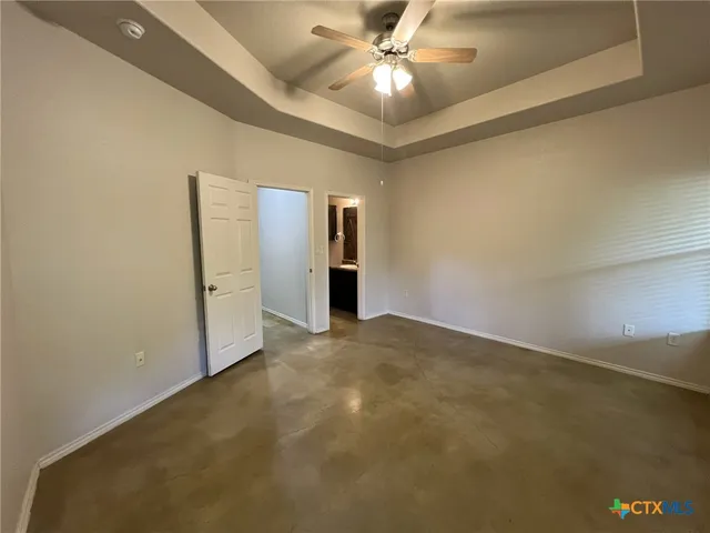 an empty room with closet and a ceiling fan