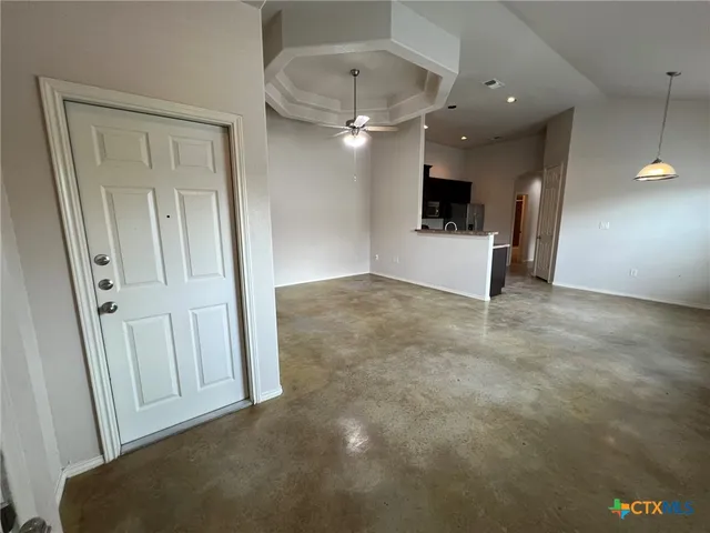 an empty room with wooden floor and a ceiling fan