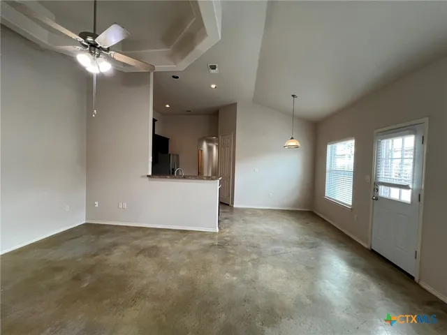 an empty room with fan and windows
