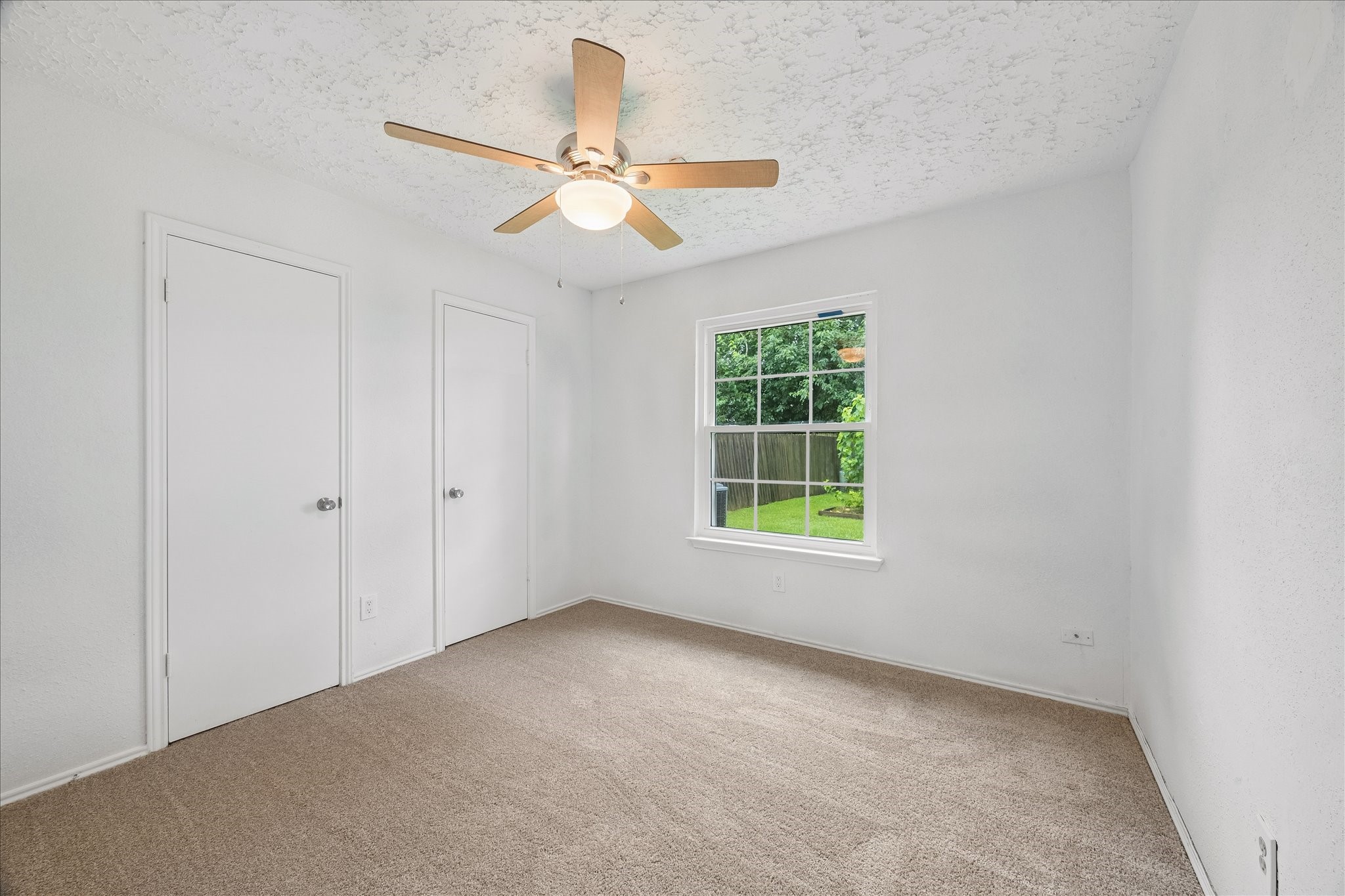 16715 Benchmark Drive Houston, TX 77053 - Photo 4 of 14 an empty room with windows and fan