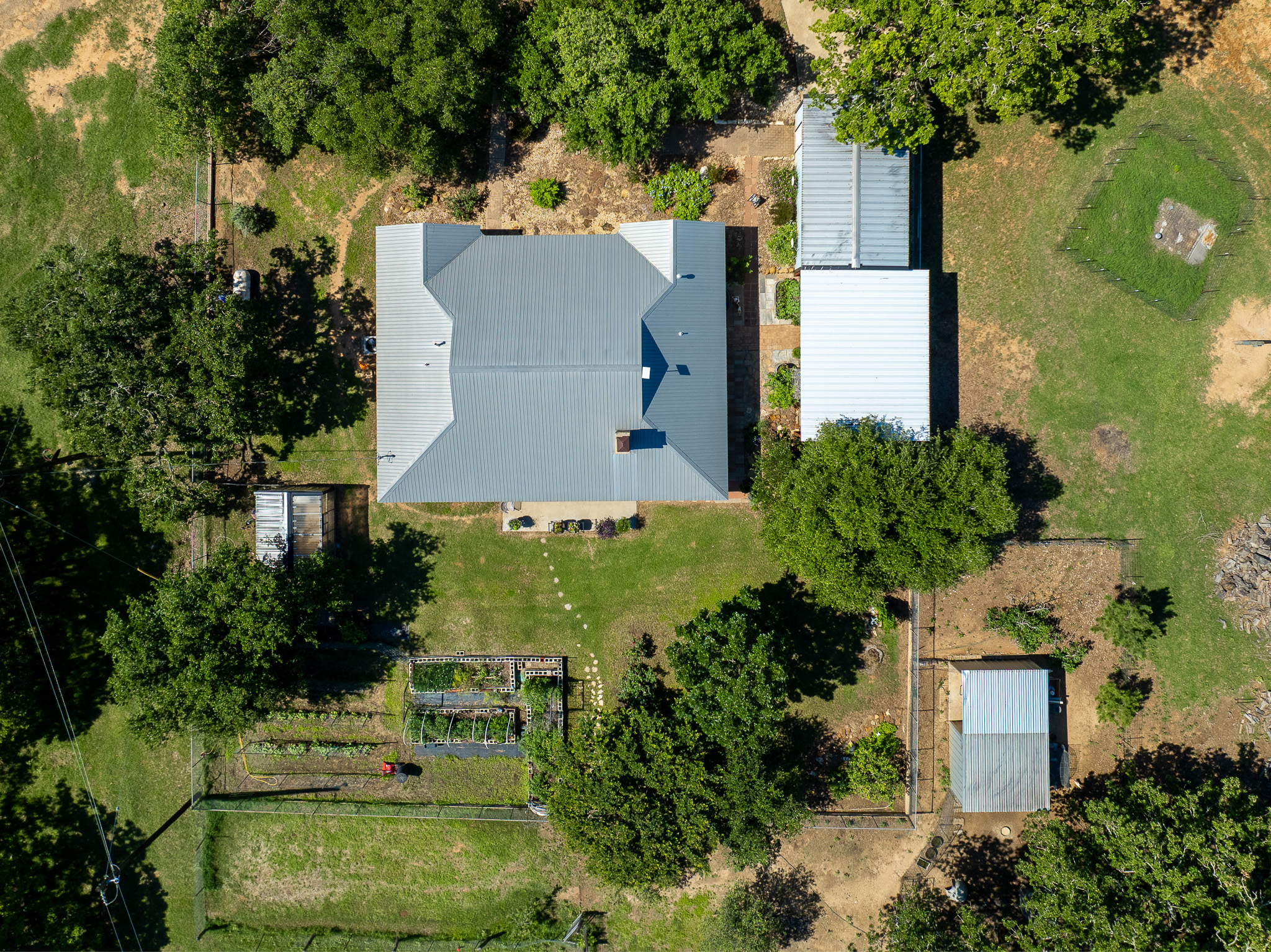 400 619th Spur Elgin, TX 78621 - Photo 22 of 40 An aerial perspective reveals a secluded estate with a spacious home, lush gardens, and several outbuildings.