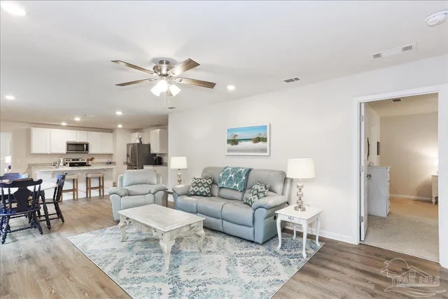 a living room with furniture and kitchen view