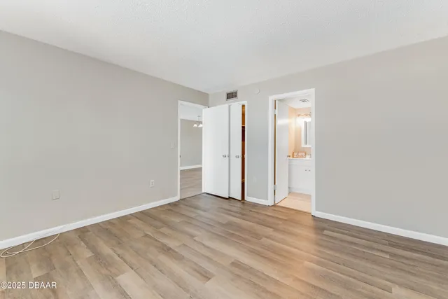 a view of an empty room with wooden floor