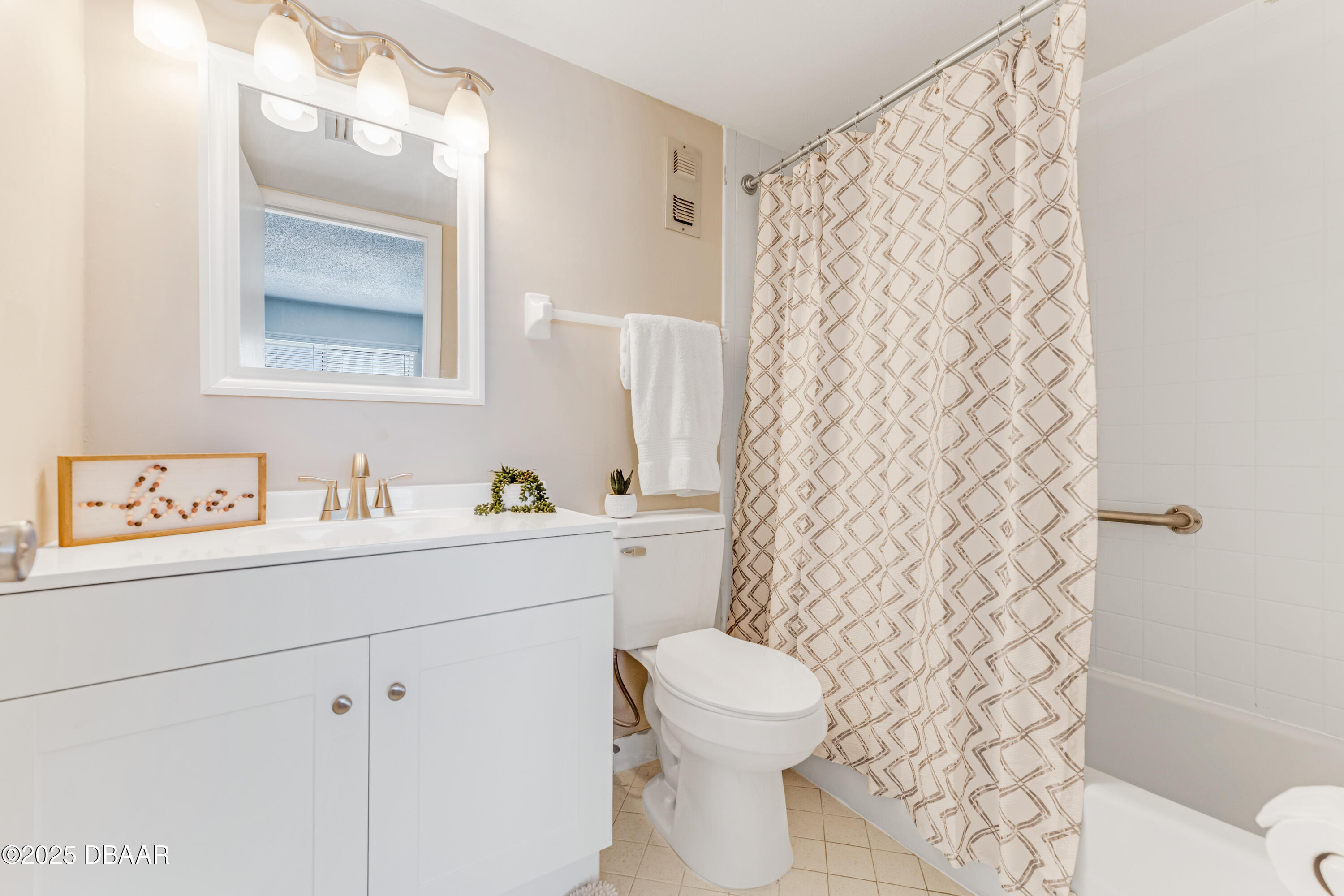 2711 North Halifax Avenue, Unit 794 Daytona Beach, FL 32118 - Photo 15 of 22 a bathroom with a sink a toilet and shower curtain