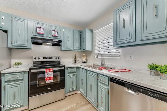a kitchen with stainless steel appliances granite countertop a sink and a stove
