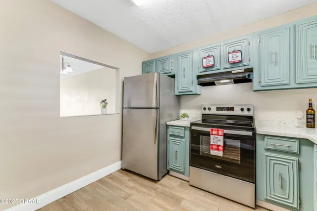 a kitchen with stainless steel appliances granite countertop a refrigerator stove and sink