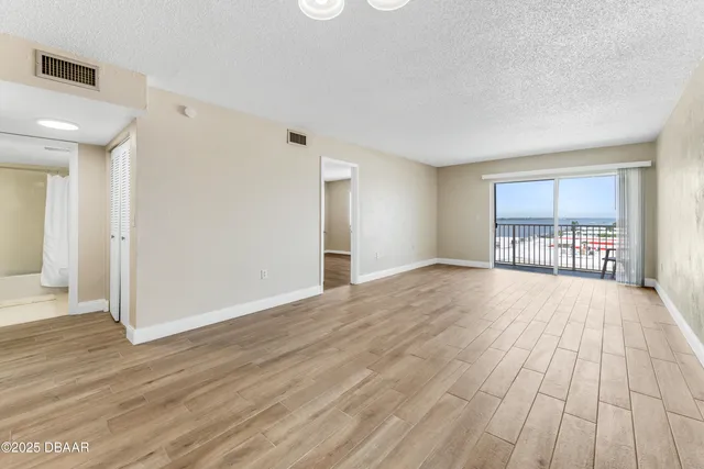 a view of empty room with wooden floor