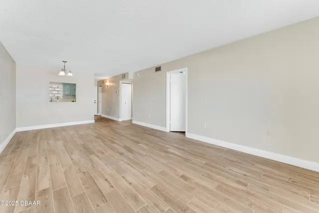 a view of an empty room and wooden floor