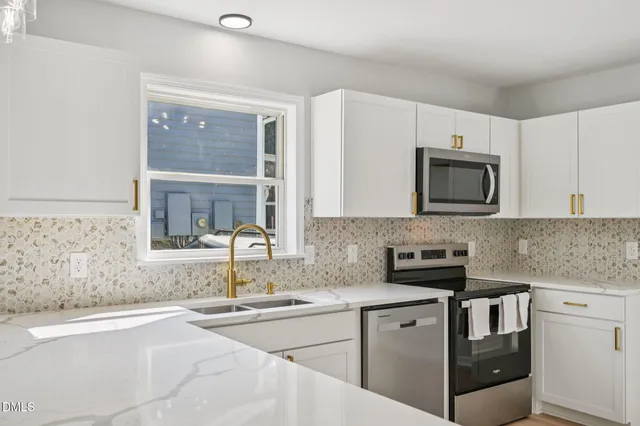 a kitchen with stainless steel appliances granite countertop a sink stove and microwave