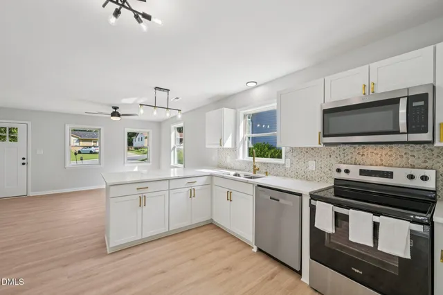 a kitchen with stainless steel appliances granite countertop a sink and stove top oven