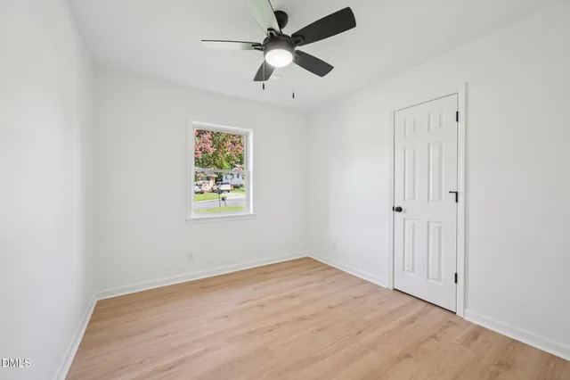 an empty room with fan and windows