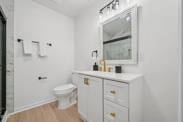 a bathroom with a toilet a sink a vanity and mirror