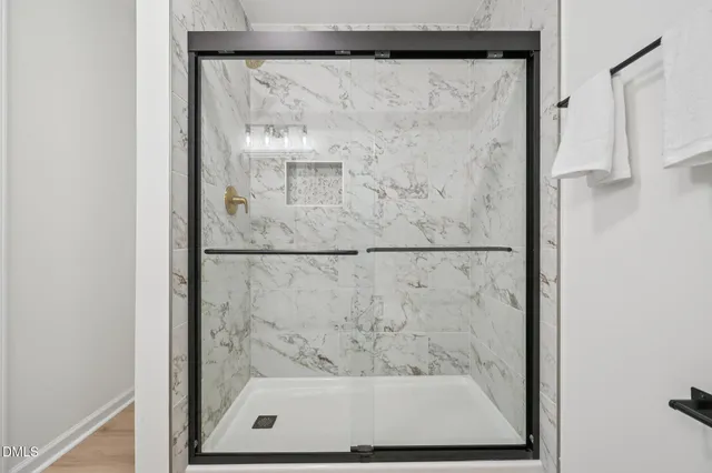 a bathroom with a glass shower door and a window