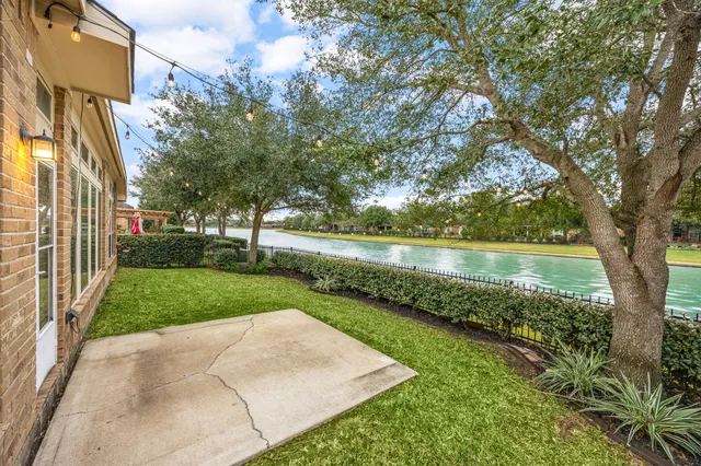 a view of a lake with a big yard and large trees