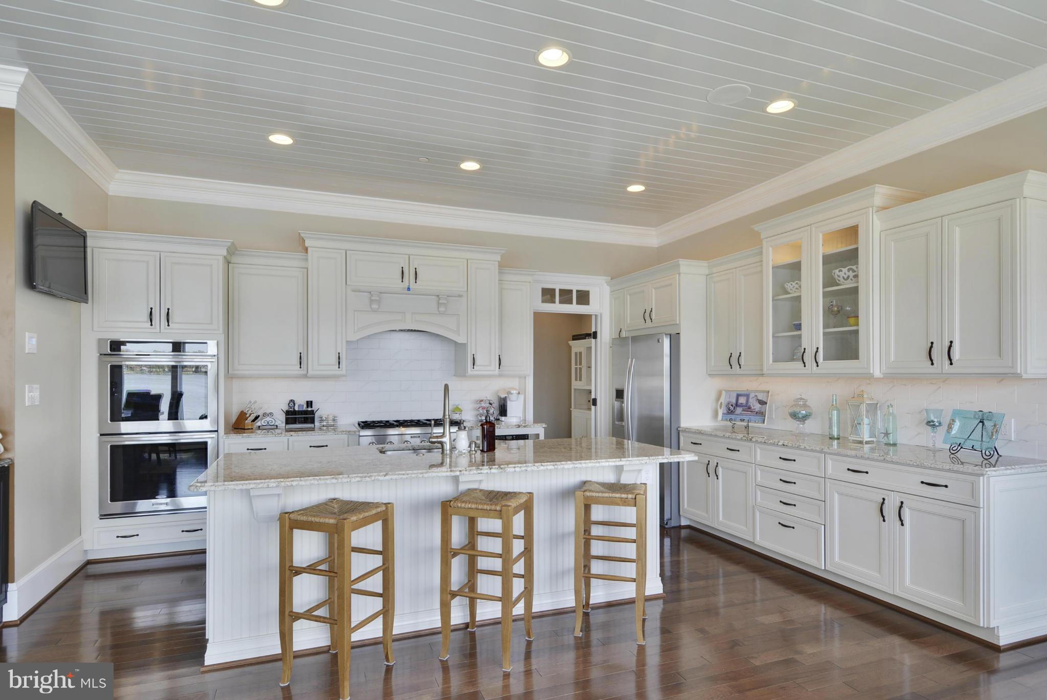 1824 Wilson Point Road Baltimore, MD 21220 - Photo 10 of 28 a kitchen with stainless steel appliances white cabinets sink and wooden floor