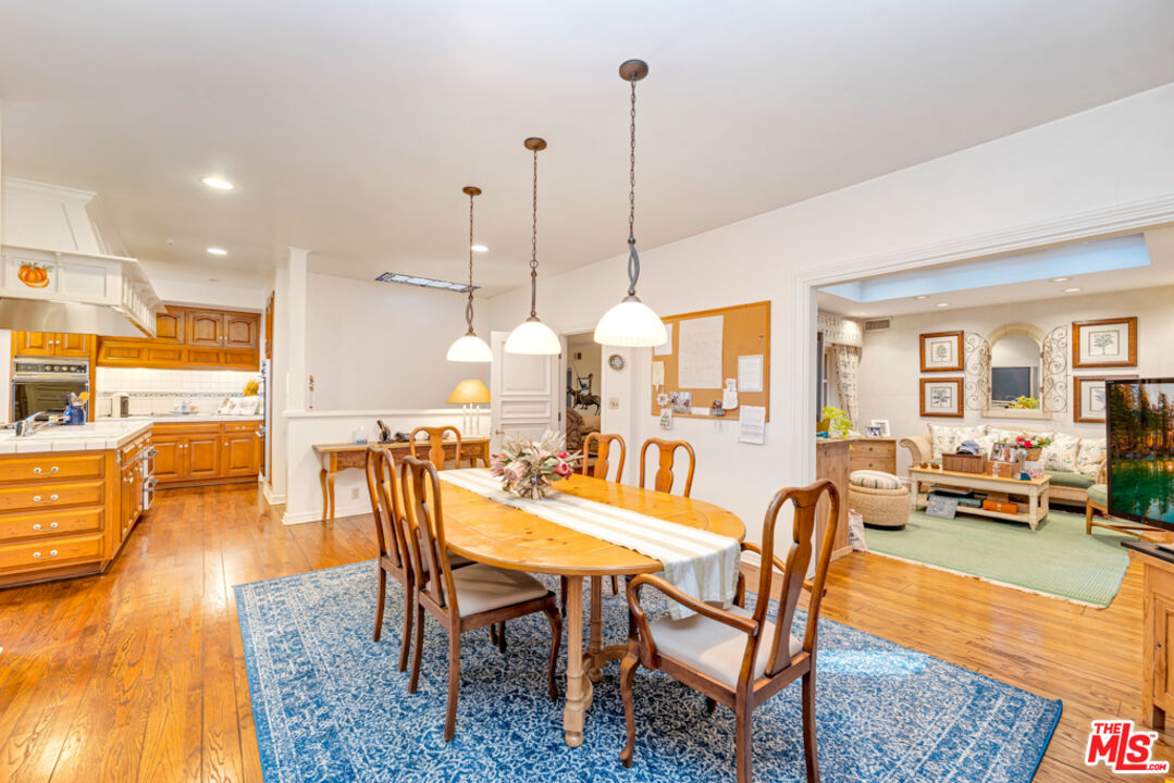 3405 Fryman Road Studio City, CA 91604 - Photo 6 of 28 a view of a dining room and livingroom with furniture wooden floor a rug a fireplace and a chandelier