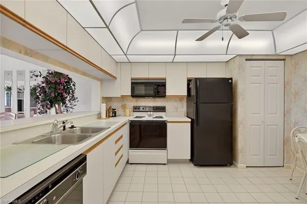 a kitchen with stainless steel appliances granite countertop a refrigerator a stove and a sink with wooden floor