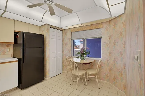 a dining room with stainless steel appliances granite countertop furniture and a refrigerator