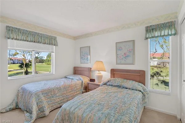a bedroom with two beds and a large window