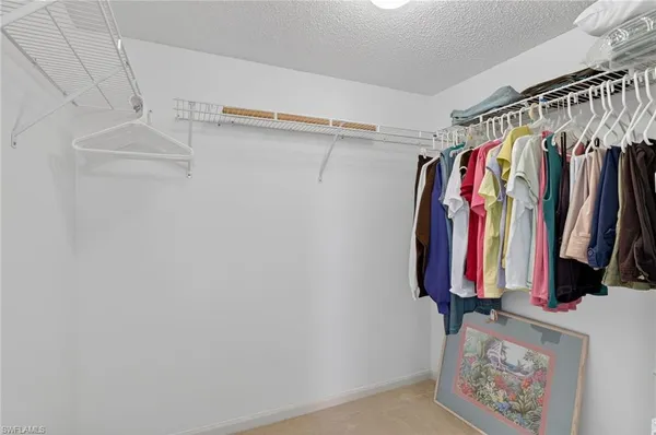a view of walk in closet with clothes