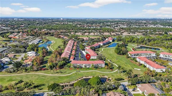 an aerial view of residential houses with outdoor space and trees