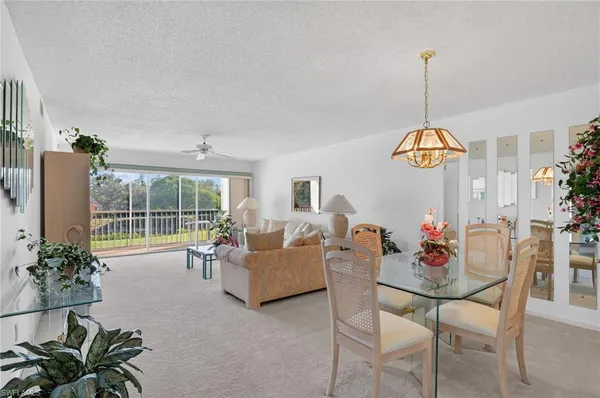 a dining room with furniture water view and a floor to ceiling window