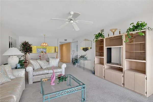 a living room with furniture a chandelier and a window