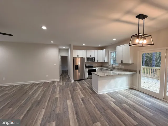 a view of kitchen with refrigerator stove and wooden floor