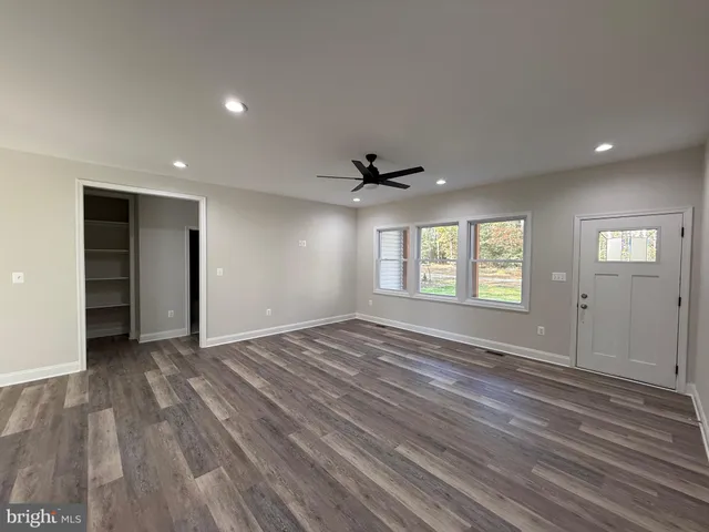 a kitchen with stainless steel appliances granite countertop a refrigerator a sink dishwasher a stove and a dining table with wooden floor