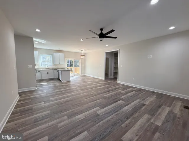 a view of empty room with wooden floor and window