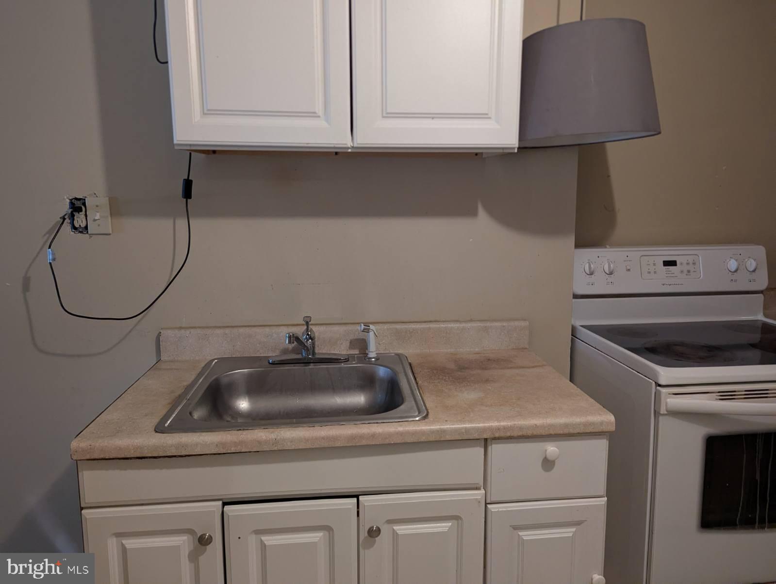 6945 Rockfield Road Baltimore, MD 21244 - Photo 9 of 10 a kitchen with white cabinets and a sink