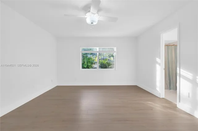 wooden floor in an empty room with a window