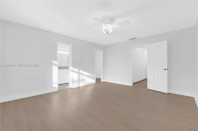 a view of an empty room with wooden floor